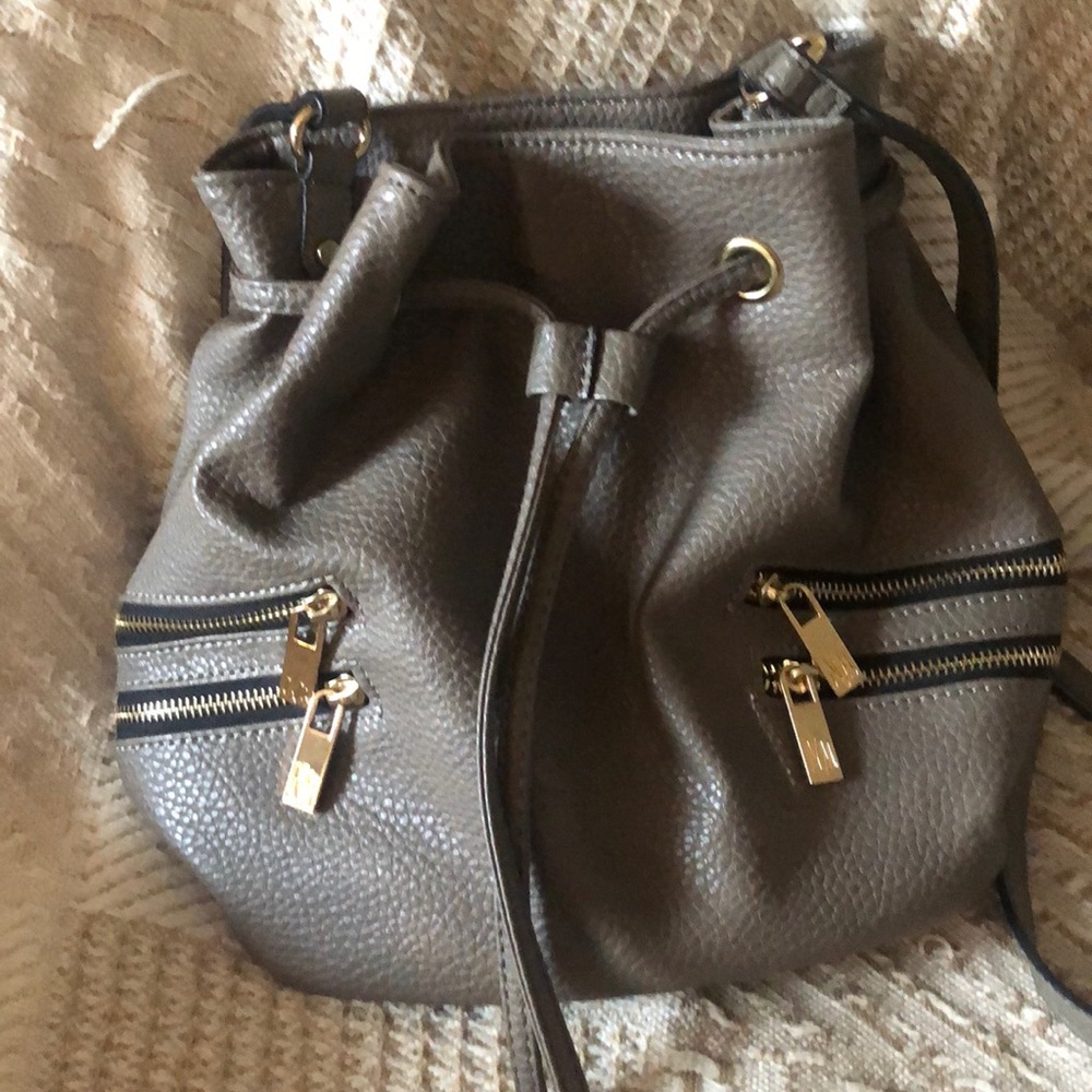 Drawstring purse with 2 interior pockets, 4 sm. zippered pockets outside